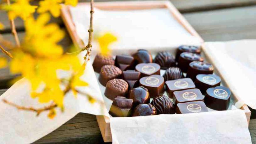 Åben, indbydende æske med fyldte chokolader.