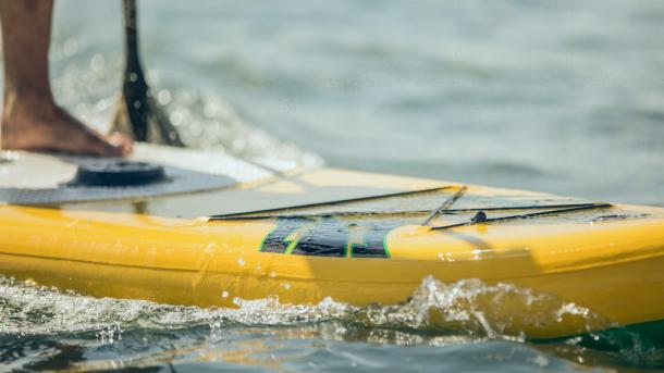 En person på gult stand up paddle board 