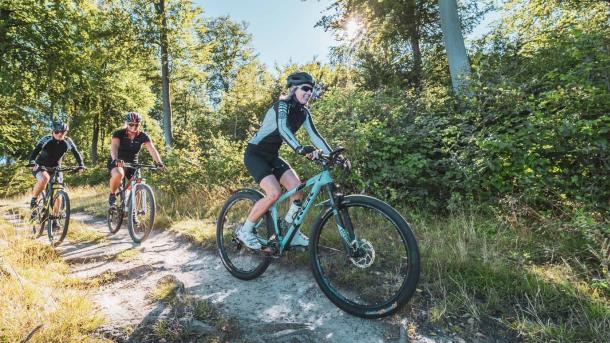 Tre personer på MTB i skov