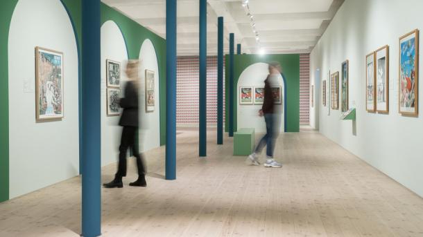 To personer ses uskarpe i en udstillingssal på Kunstmuseum Brands med billeder af kunstneren Ib Spang Olsen
