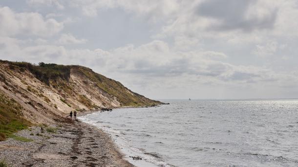 Billede af en klint ud til havet med en smal stribe sand
