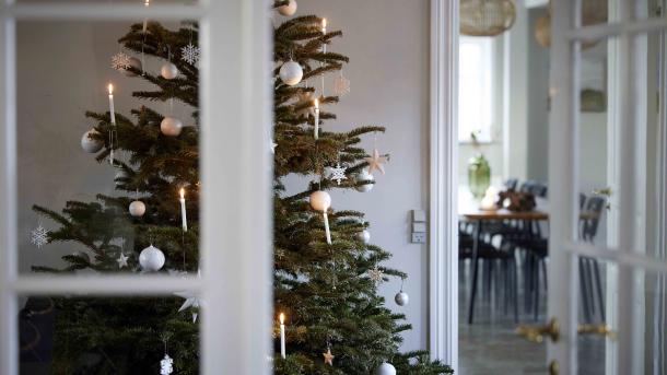 Pyntet juletræ i i et lyst rum