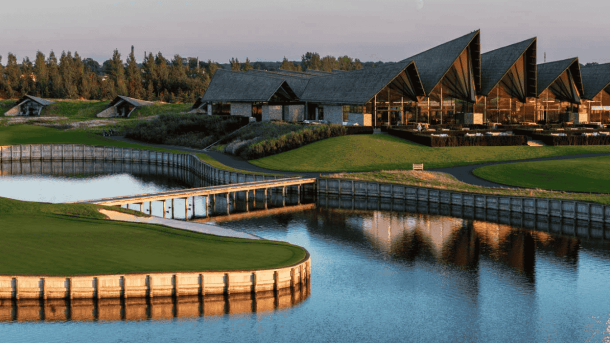 En golfbane med sø og stor ny-nordisk bygningskompleks