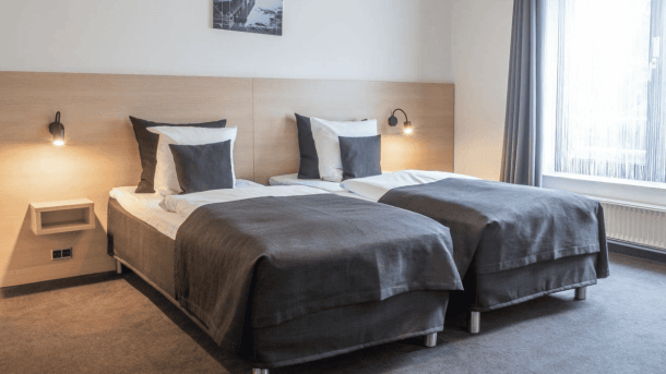 Et hotelværelse med opredte enkeltsenge