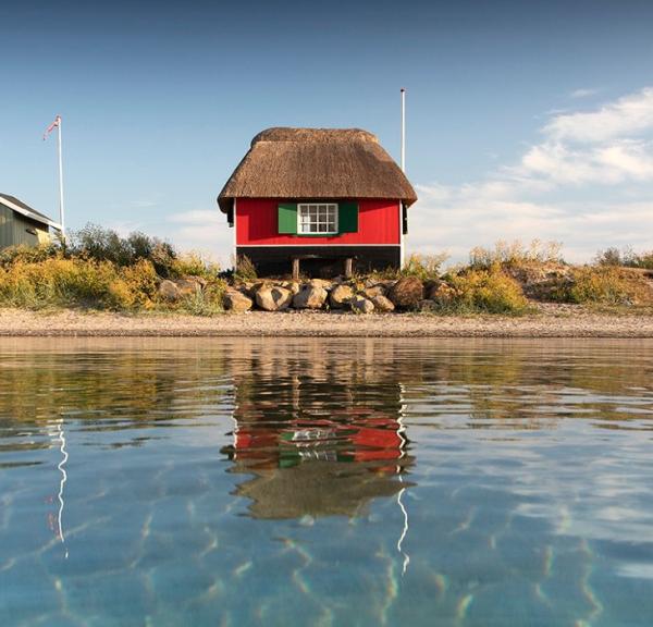 Tre badehuse ved Eriks Hale ved Marstal. Blå himmel og blåt vand.