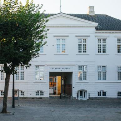 Hvid bygning med træ foran