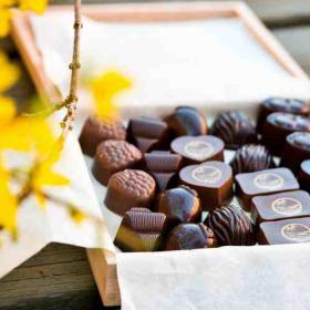 Åben, indbydende æske med fyldte chokolader.