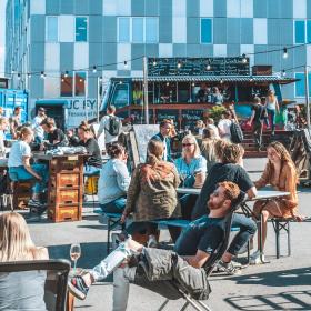 En flok mennesker sidder udenfor på et Street Food-marked.