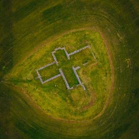 Luftfoto af Findstrup Kirkeruin. Et grønt område, hvor murbrokker danner omridset af den tidligere Findstrup Kirke.